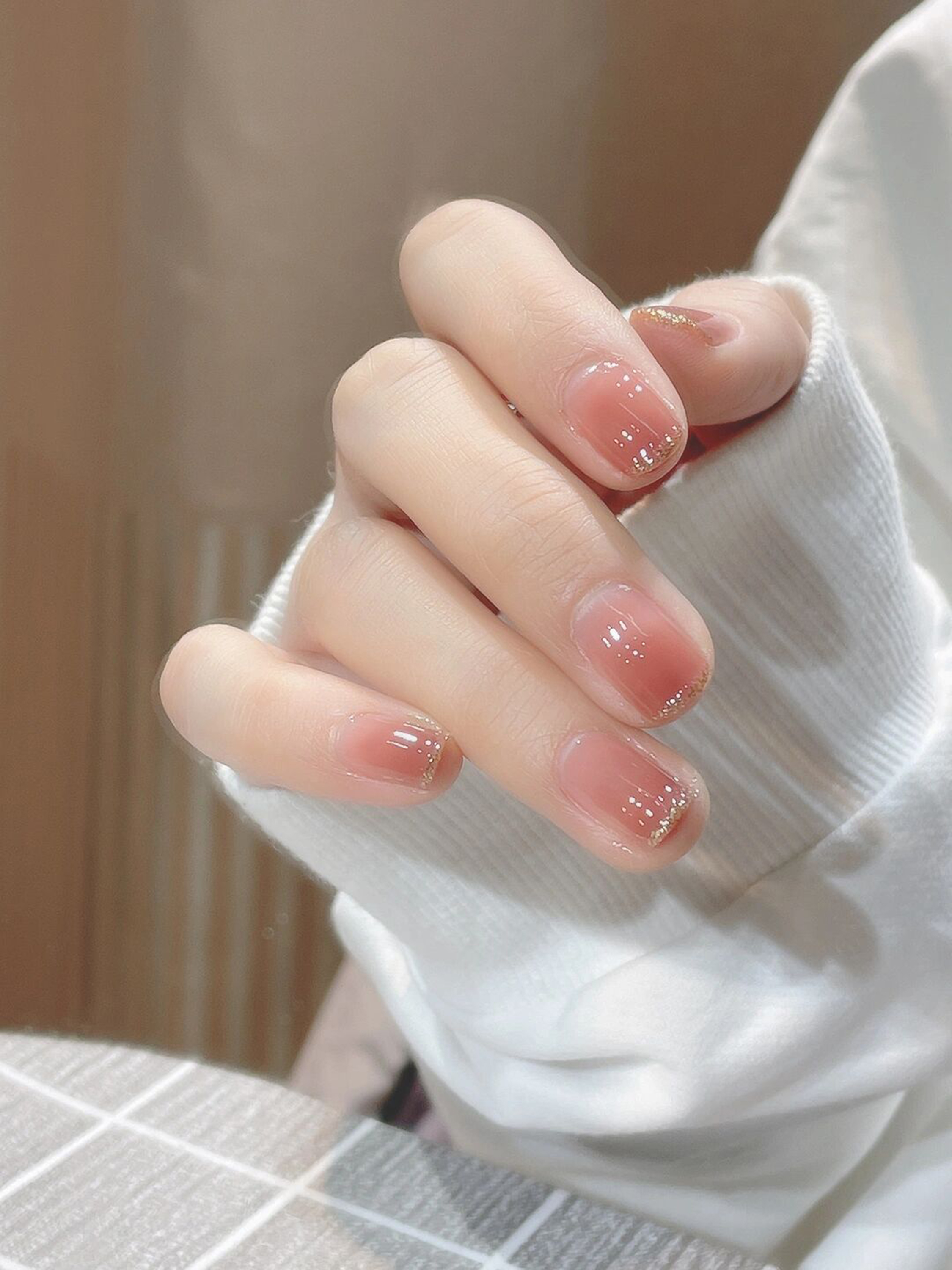 Gold and Nude Glitter Short Nails shown as a nail art design with gold, nude, elegant, simple, glitter and short details.