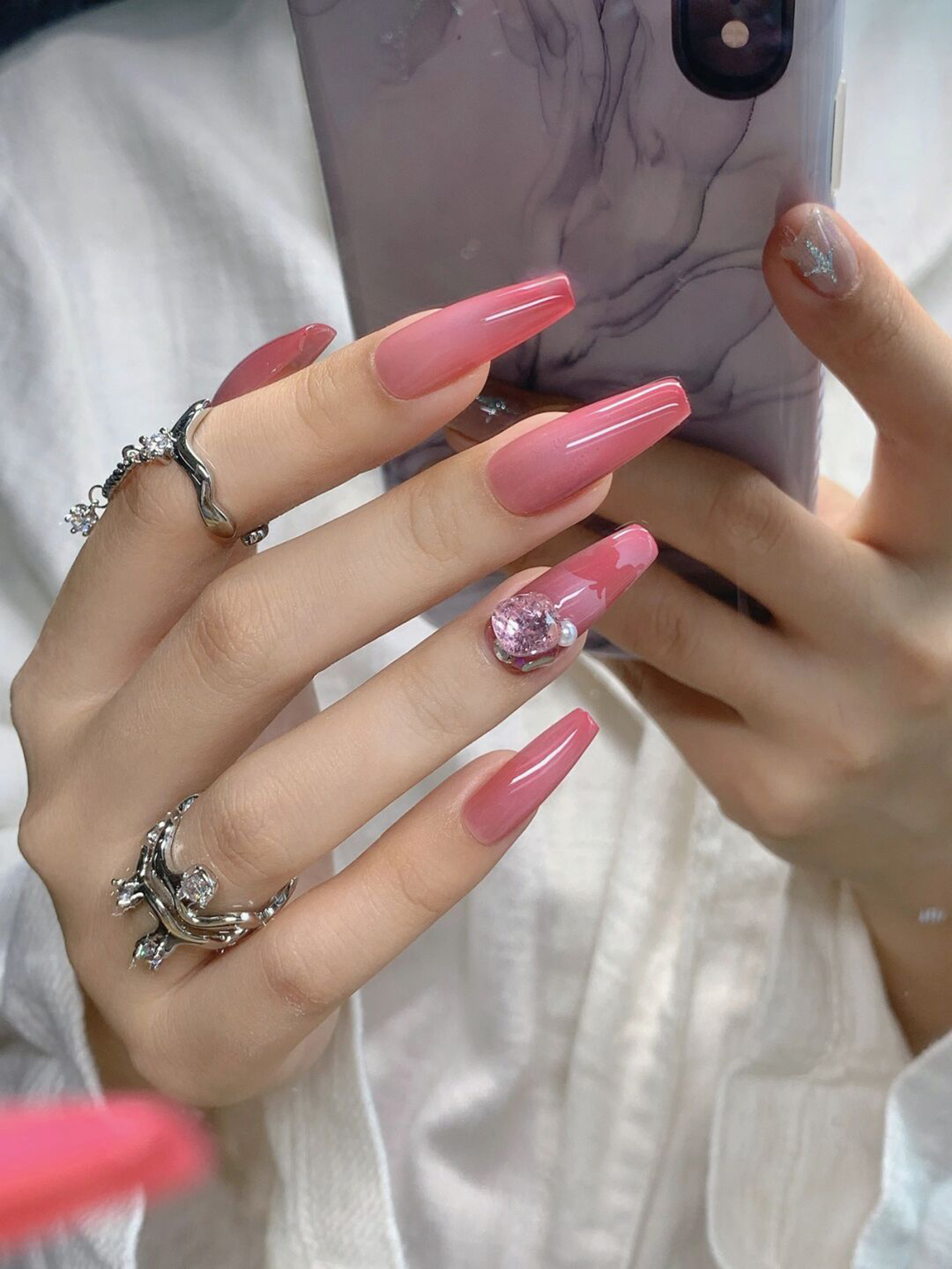 Pink long coffin nail art with rhinestone accent and glossy finish.
