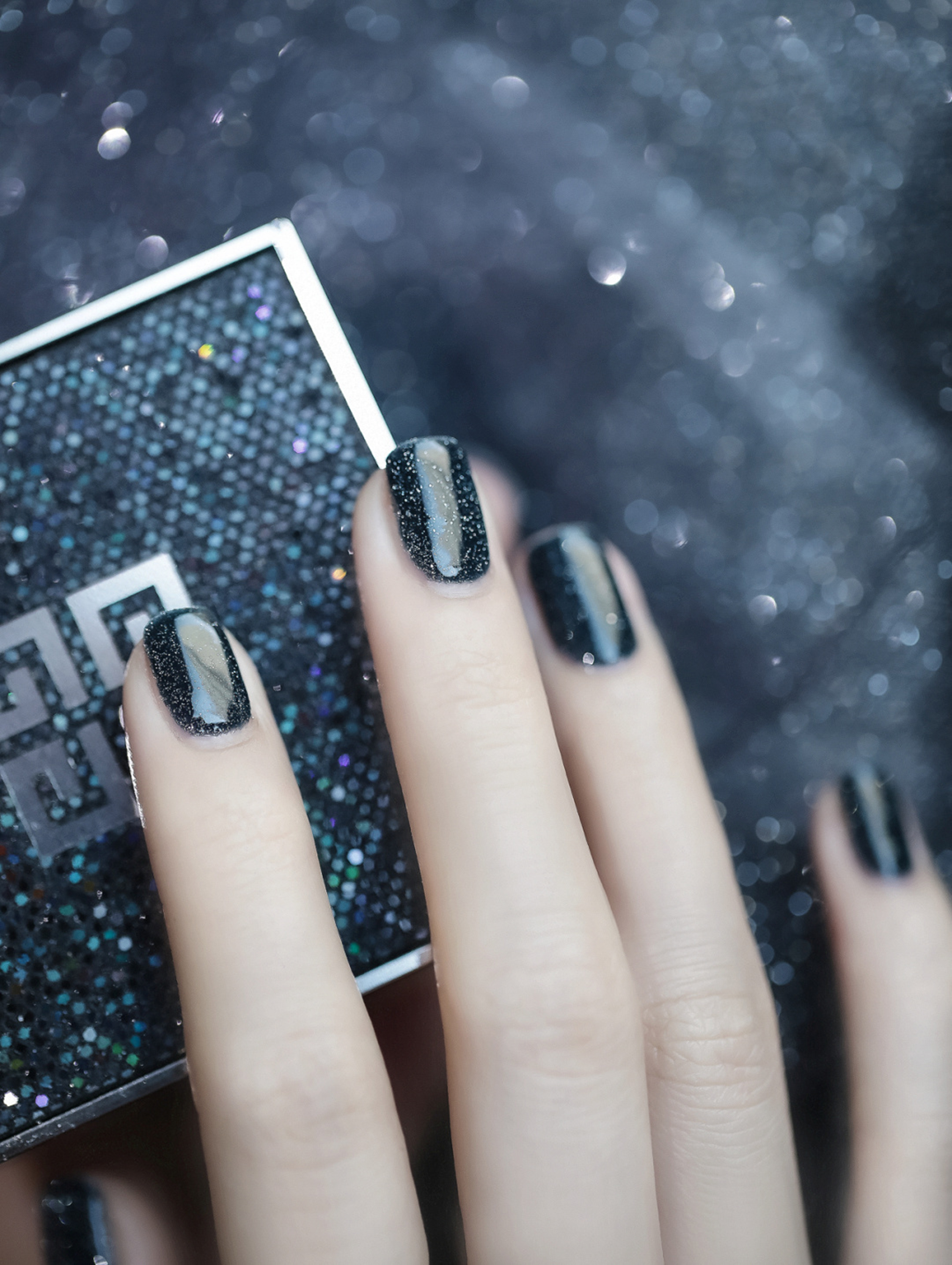 Black square nails with silver glitter accents and glossy shine.