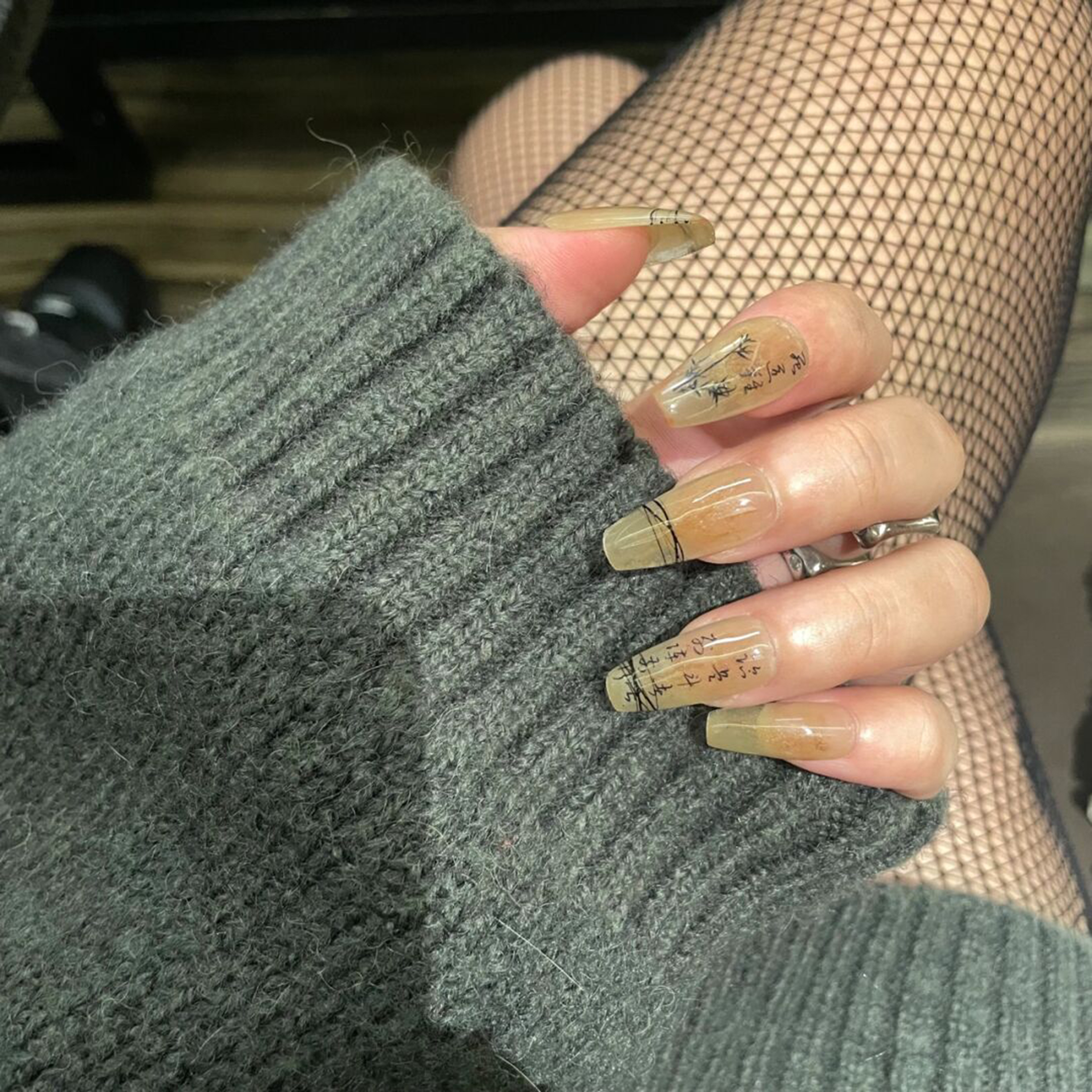 Nude long coffin nails with fine black abstract line art.