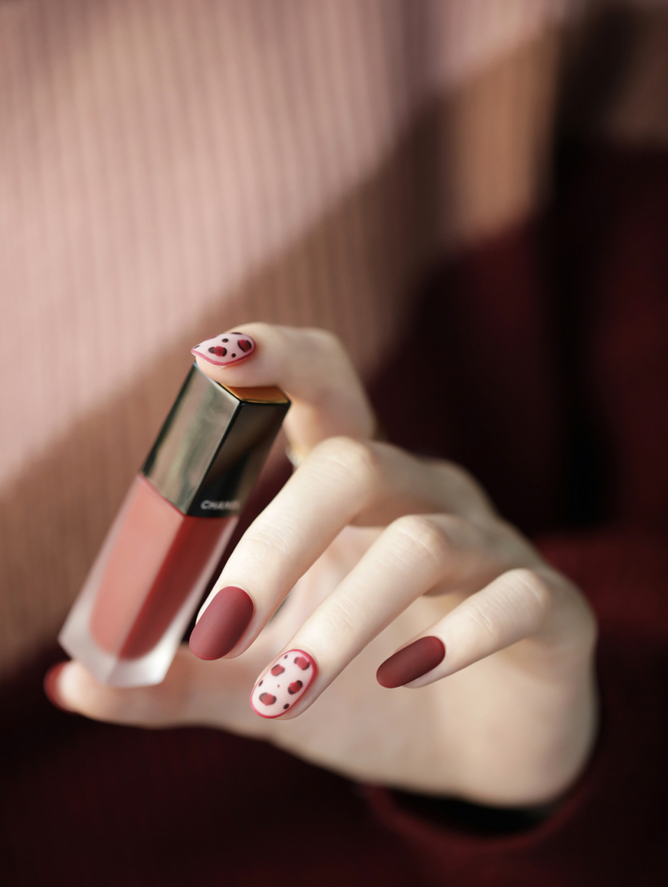 Red and white oval nail art with small heart accents.