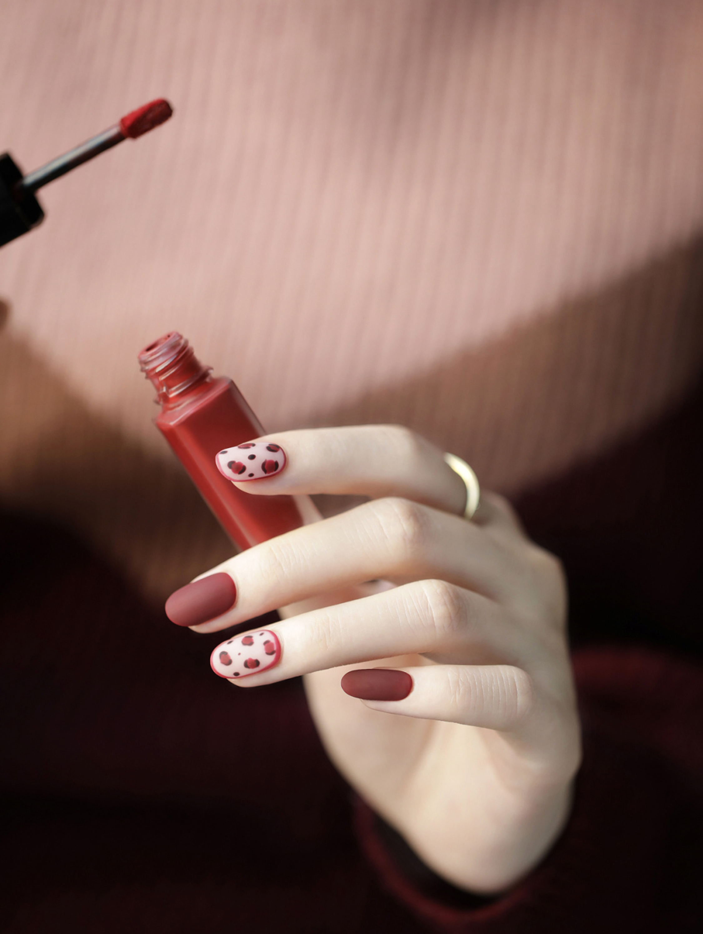 Nude and Dark Red Polka Dot Almond Nails shown as a nail art design with nude, dark red, minimal, cute, elegant, polka dot, almond and medium details.