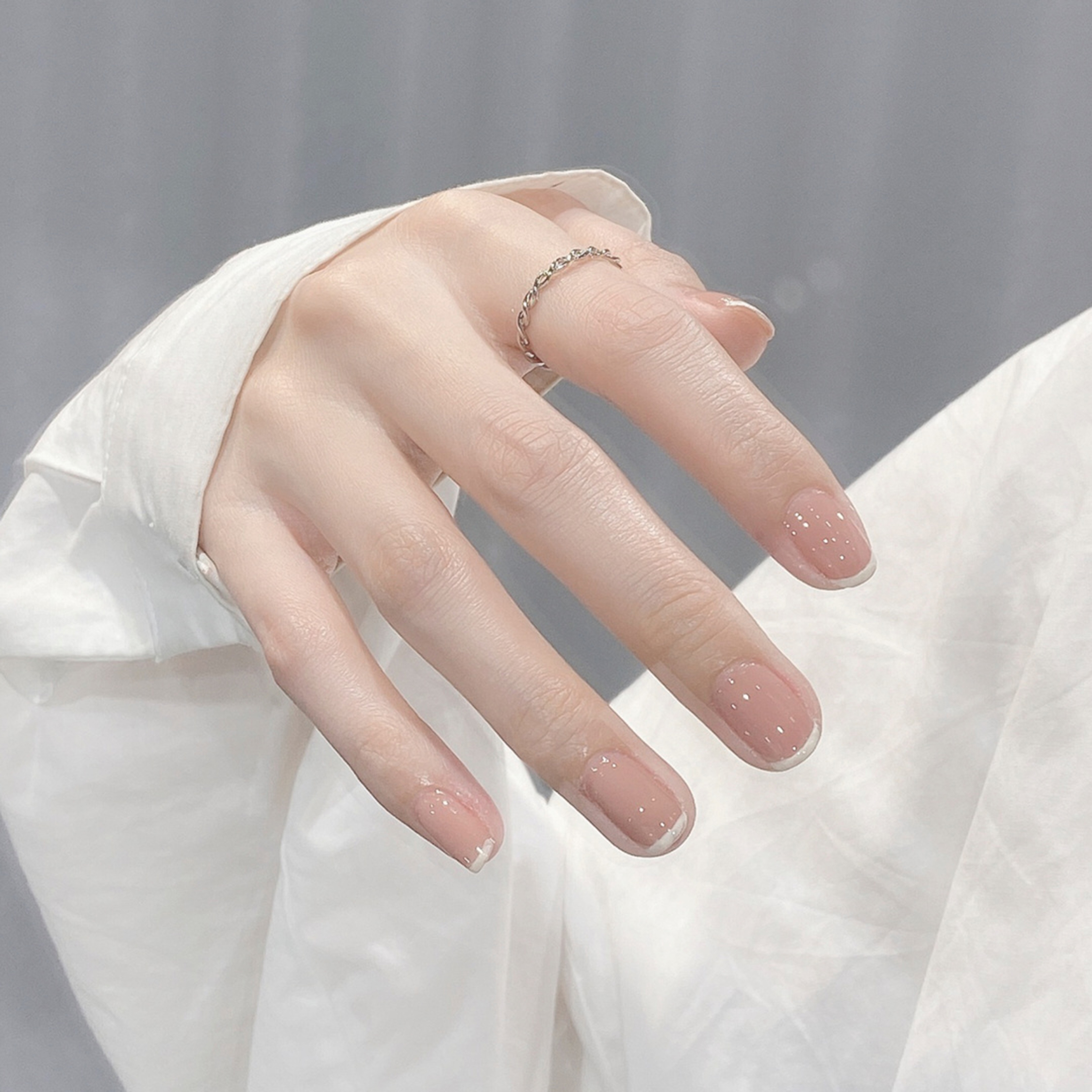 Nude and White French Tip Short Round Nails shown as a nail art design with nude, white, french, round and short details.