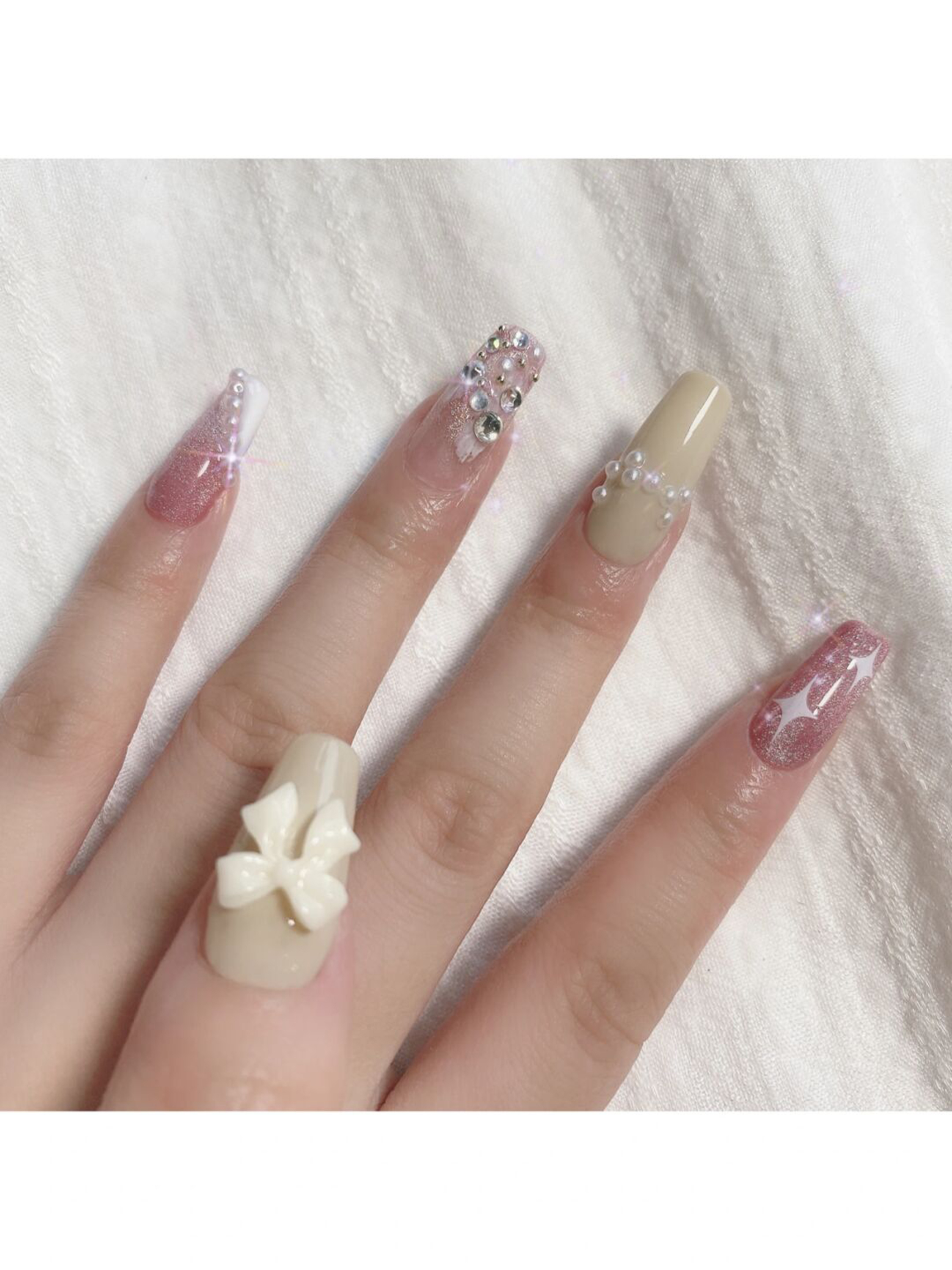 Nude and White Bow Long Stiletto Nails shown as a nail art design with nude, white, elegant, coquette, bow, stiletto and long details.