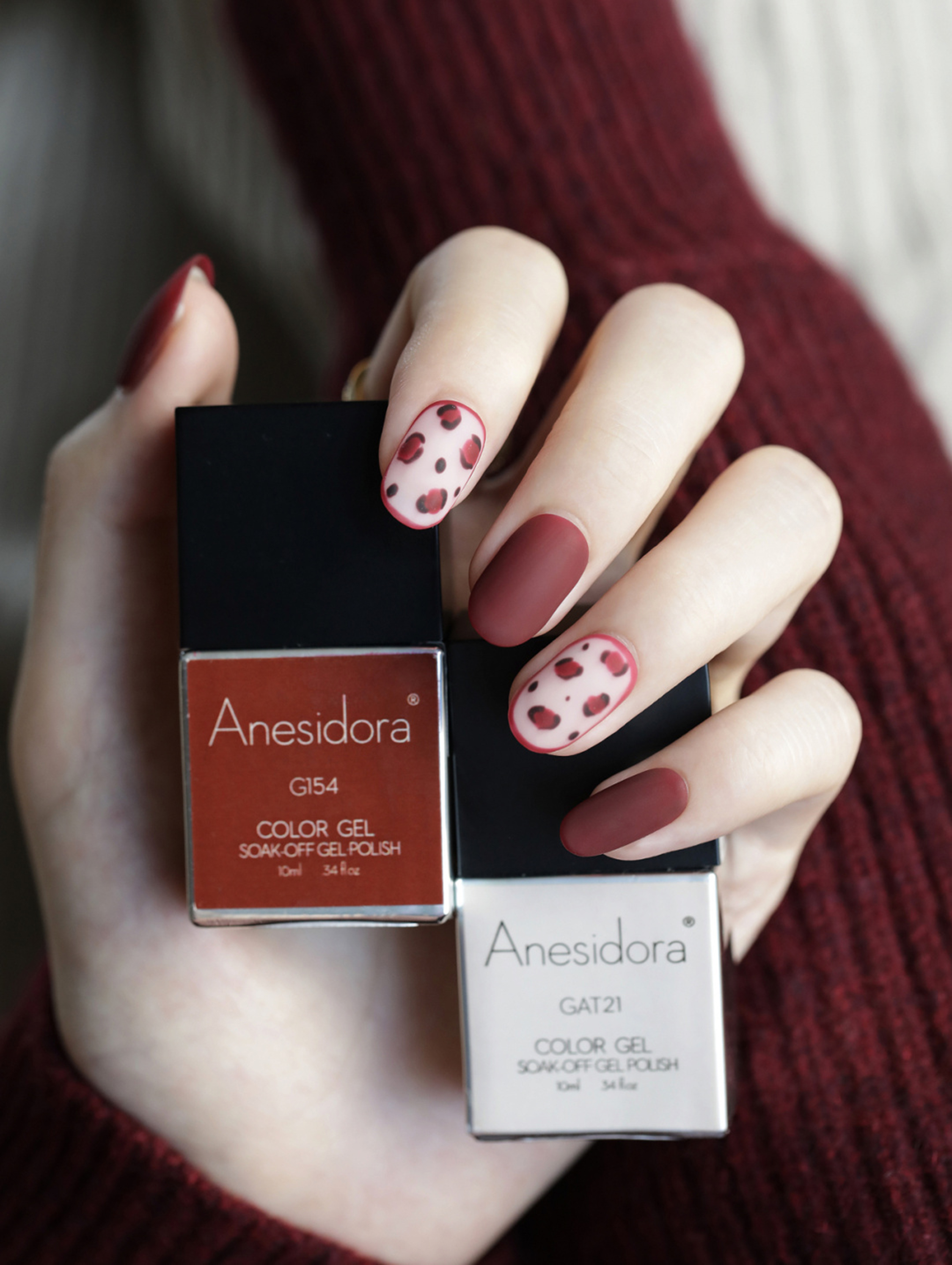 Red and white oval nails with polka dot accent design.