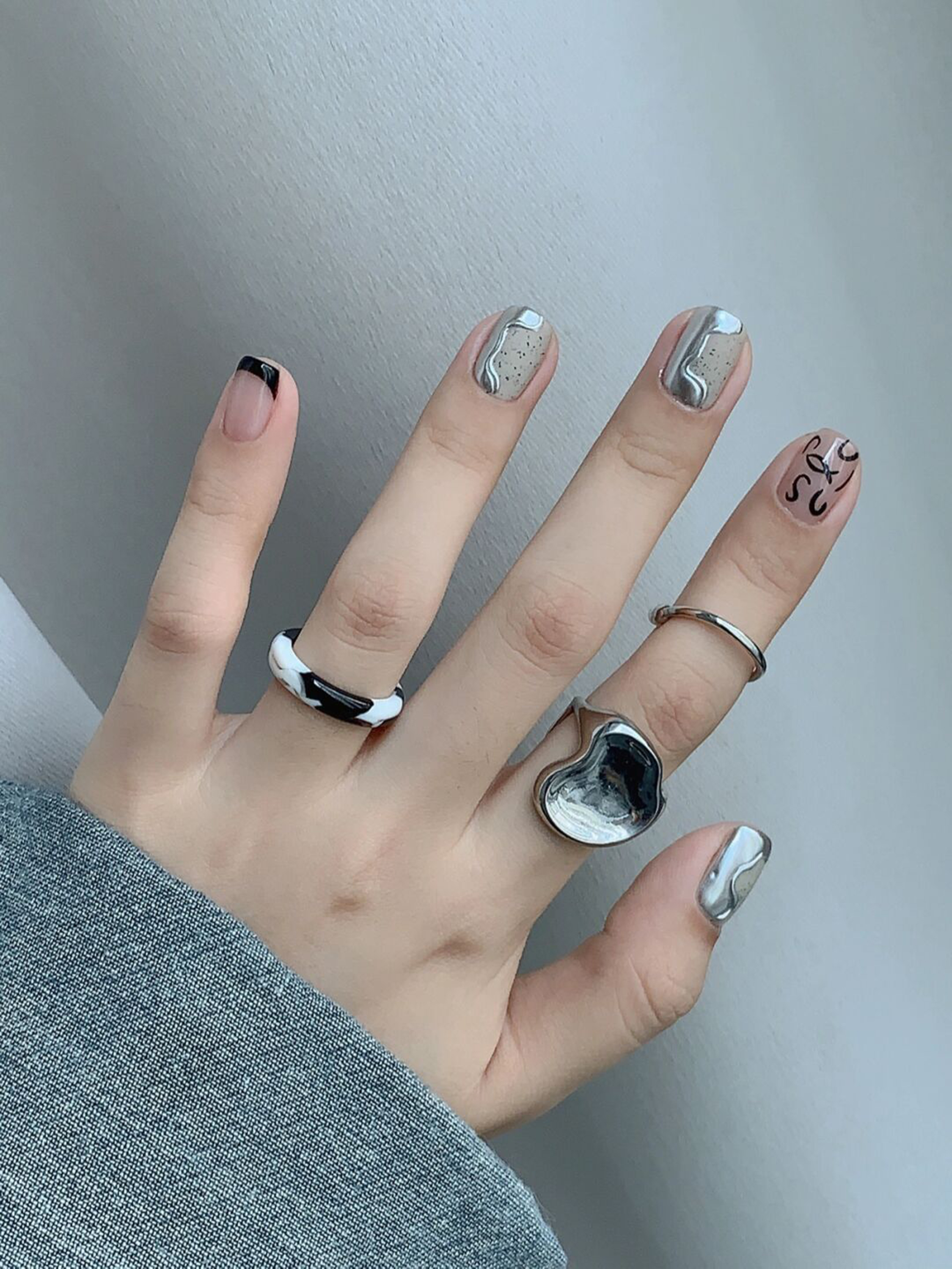 Black, Silver and White Abstract Short Nails shown as a nail art design with black, silver, white, abstract, swirl and short details.