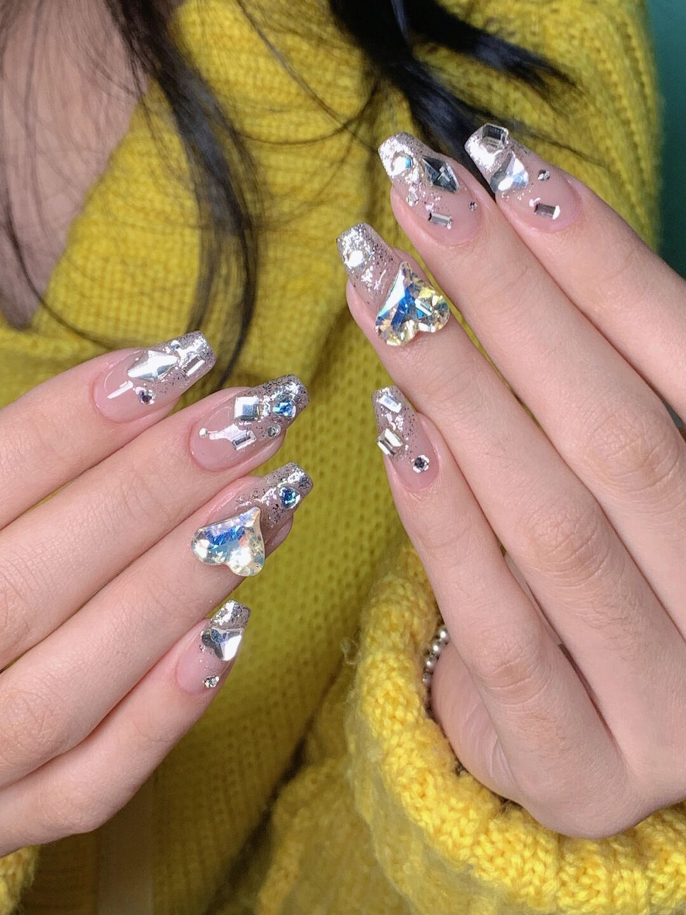 Silver chrome long almond nails with a reflective finish.