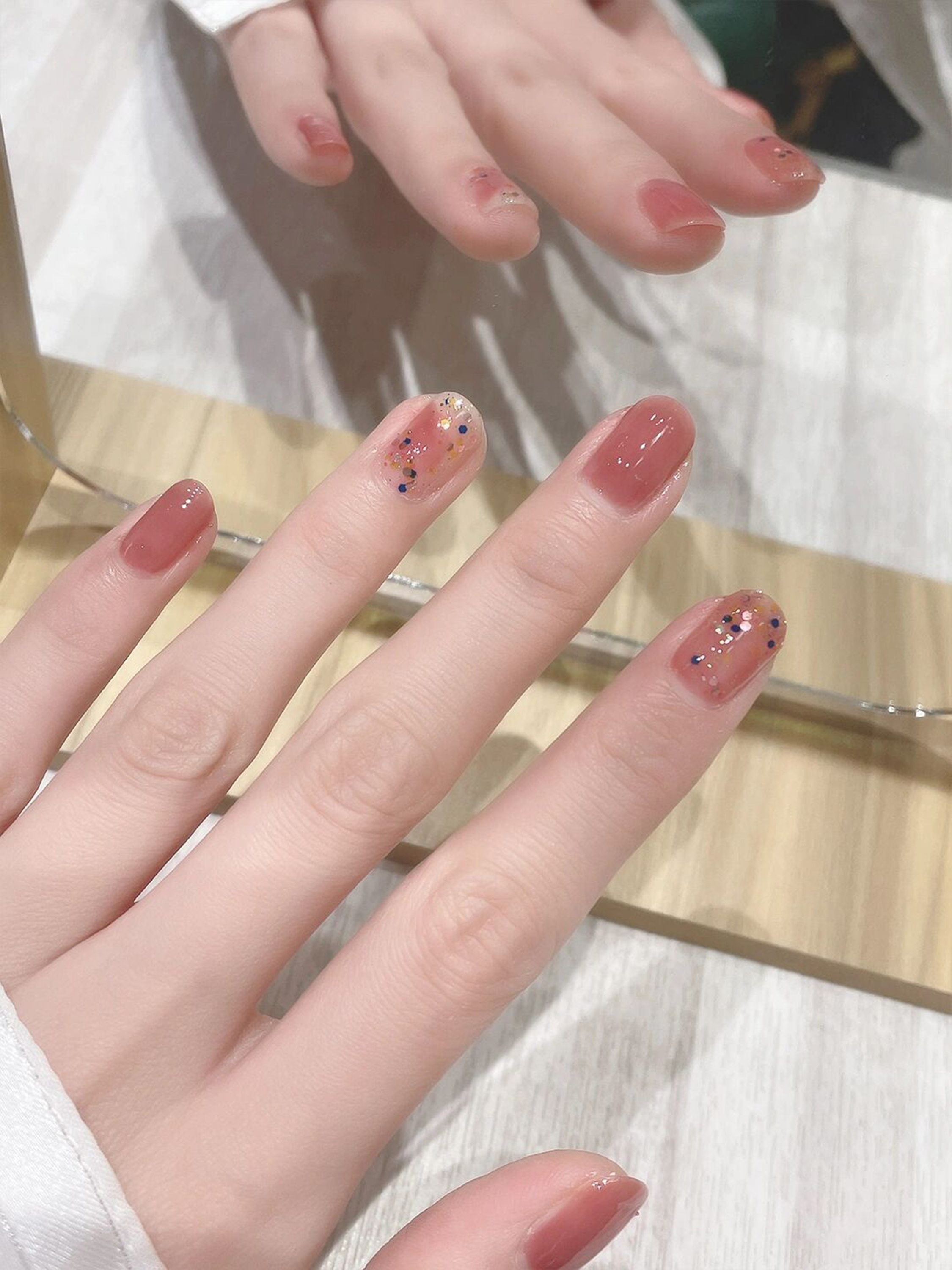 Pink nude glitter short oval nails with a soft glossy finish.