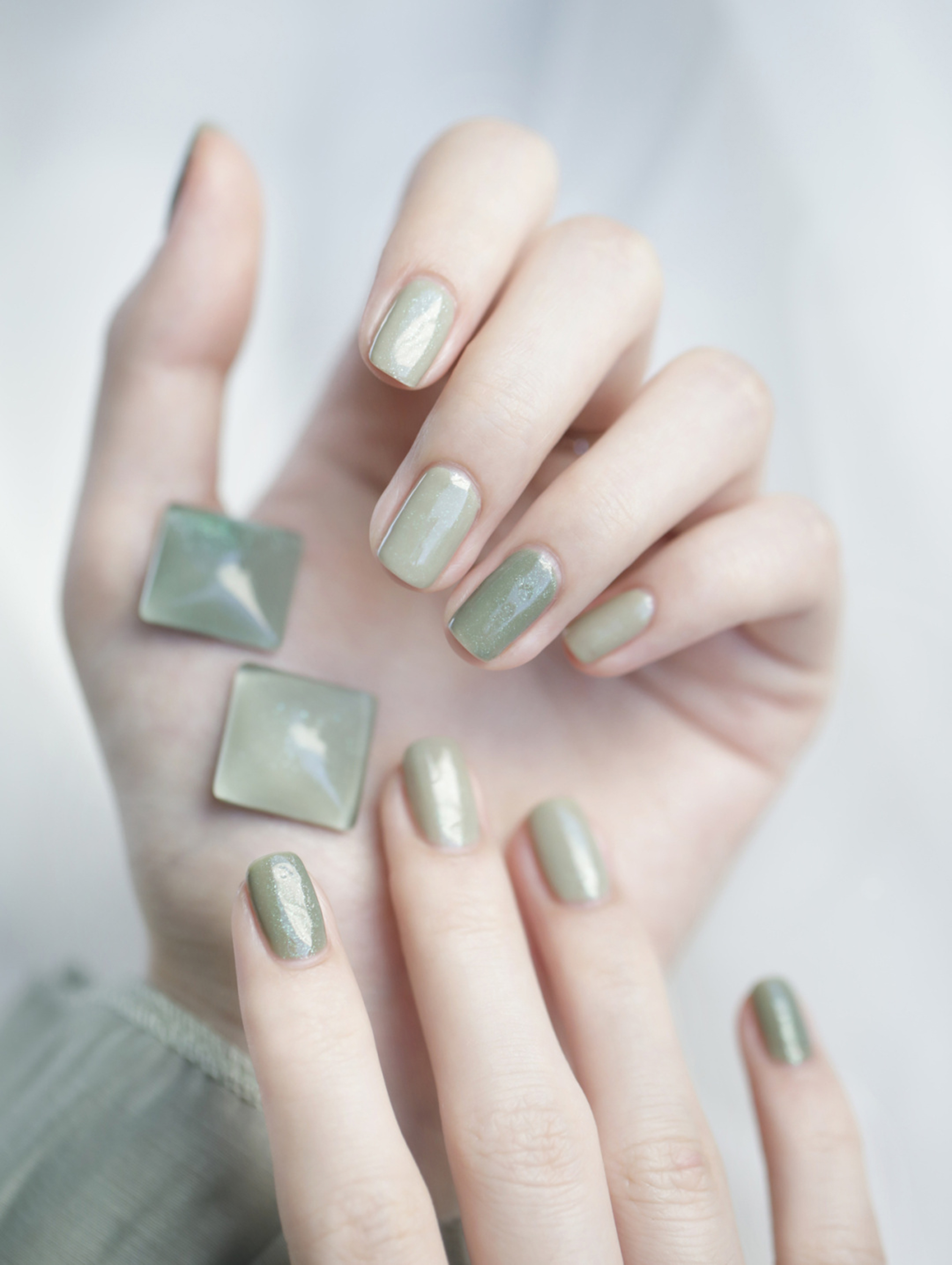 Green chrome short square nails with a reflective finish.