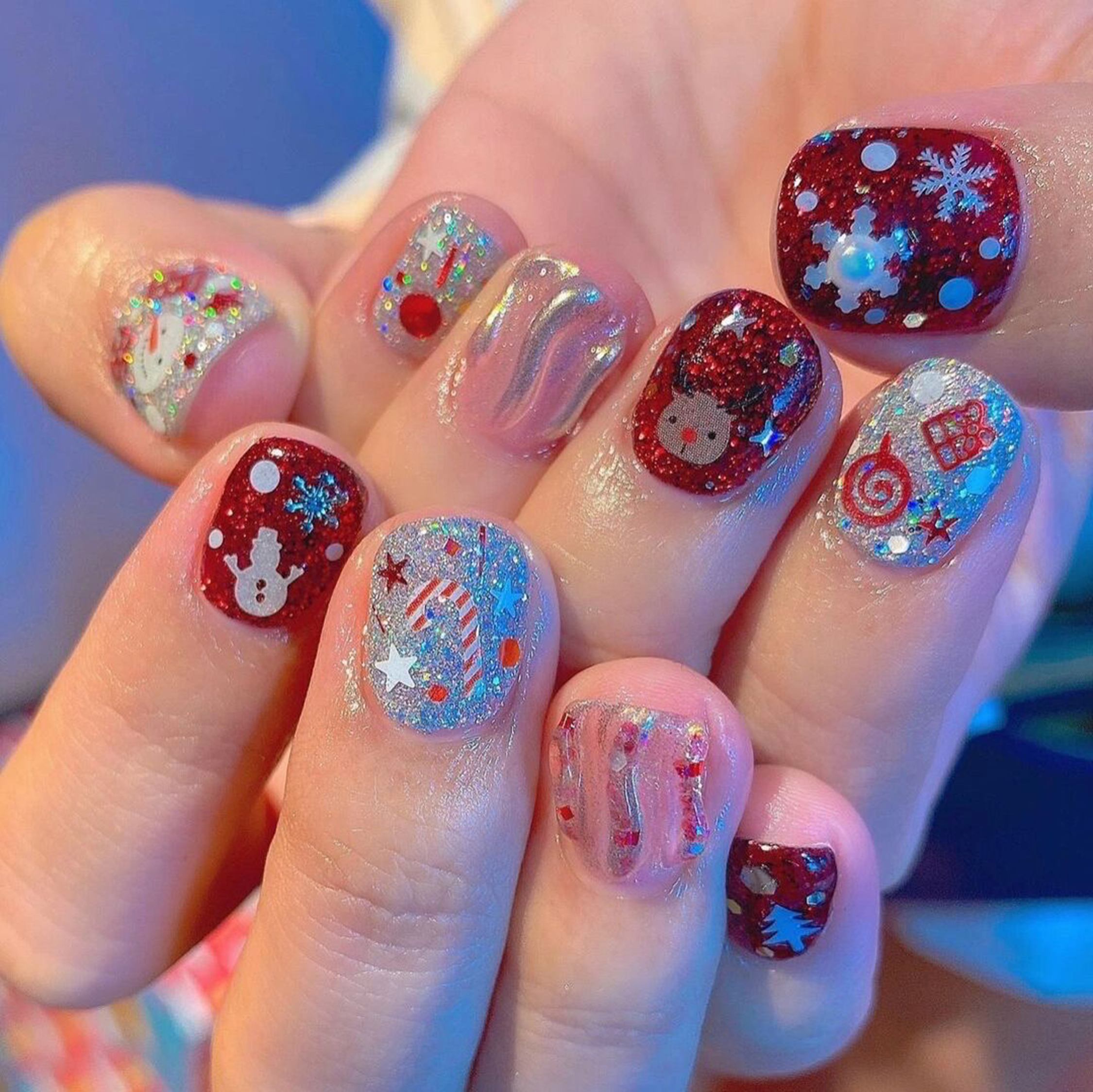 Red and Blue Floral Short Round Nails shown as a nail art design with red, blue, glitter, gel, flower, round and short details.
