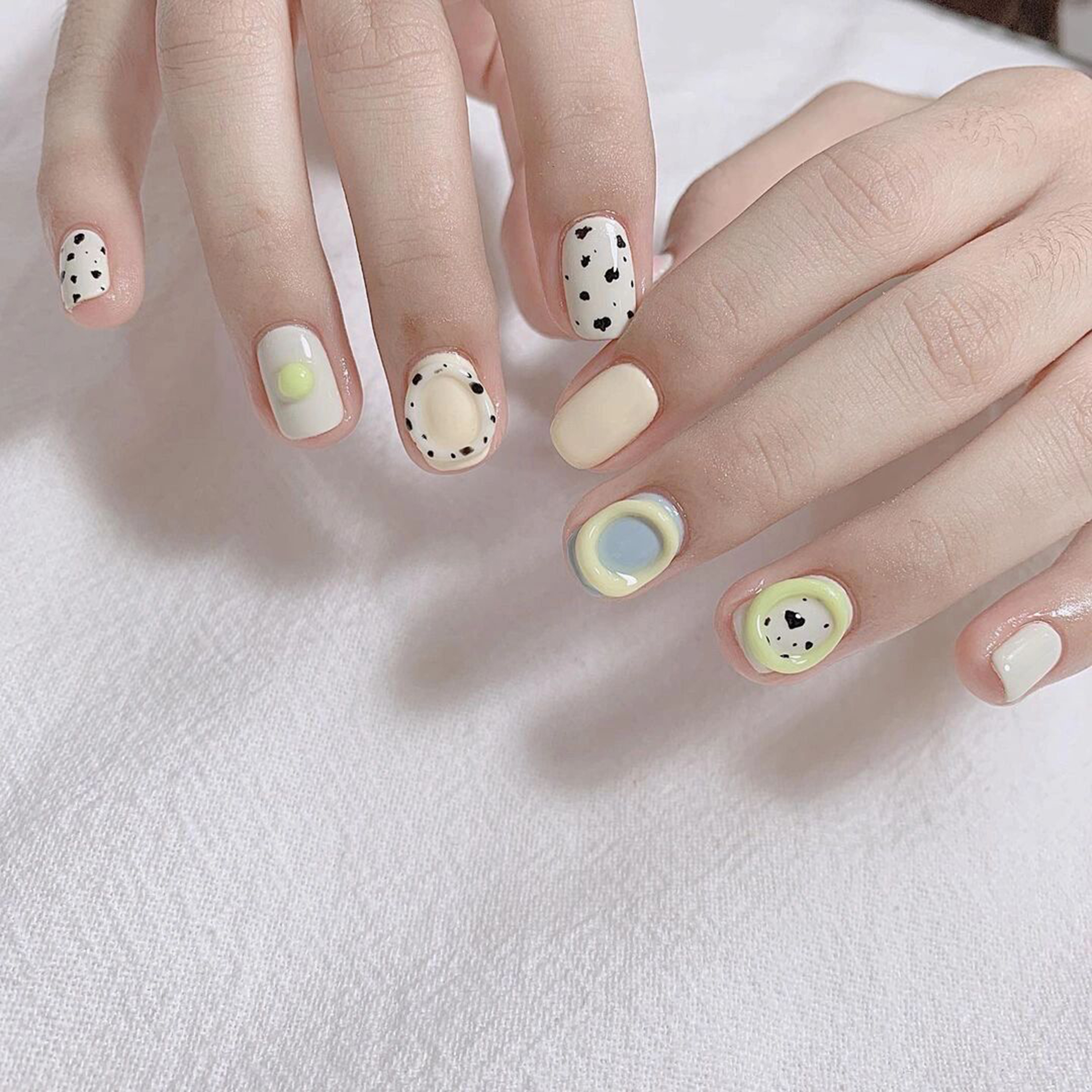 White, Pastel and Black Polka Dot Short Round Nails shown as a nail art design with white, pastel, black, cute, minimal, polka dot, round and short details.