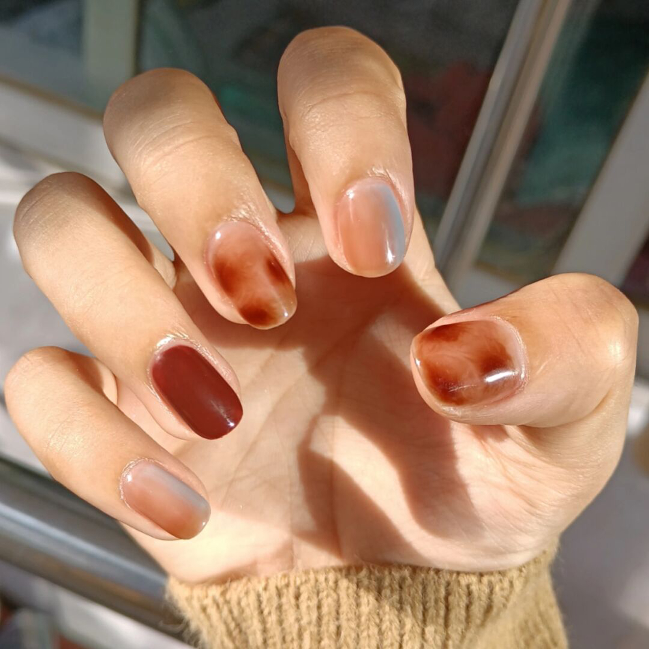 Nude and Brown Marble Oval Nails shown as a nail art design with nude, brown, marble, elegant, oval and medium details.