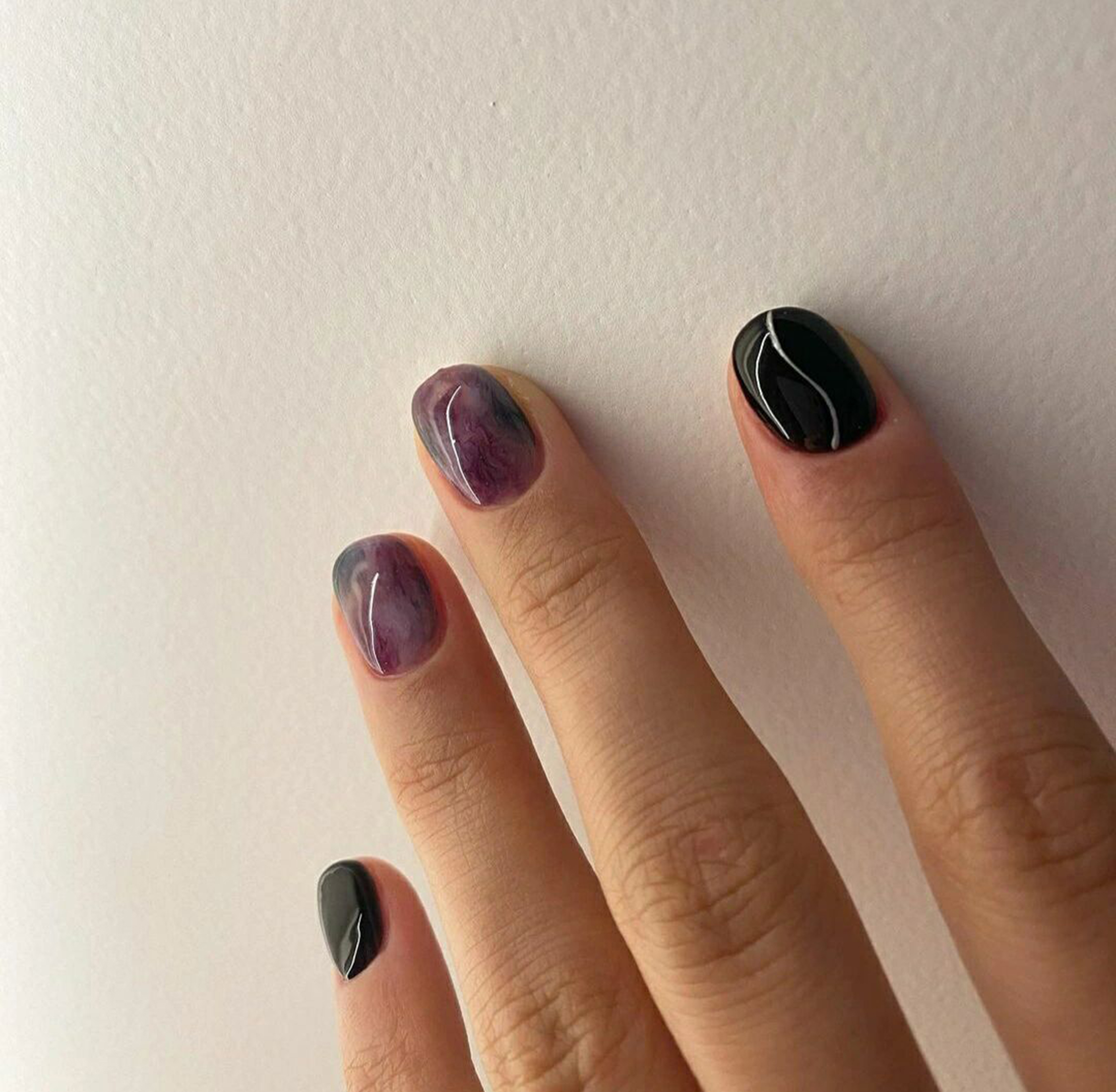 Black and Purple Marble Short Round Nails shown as a nail art design with black, purple, marble, round and short details.