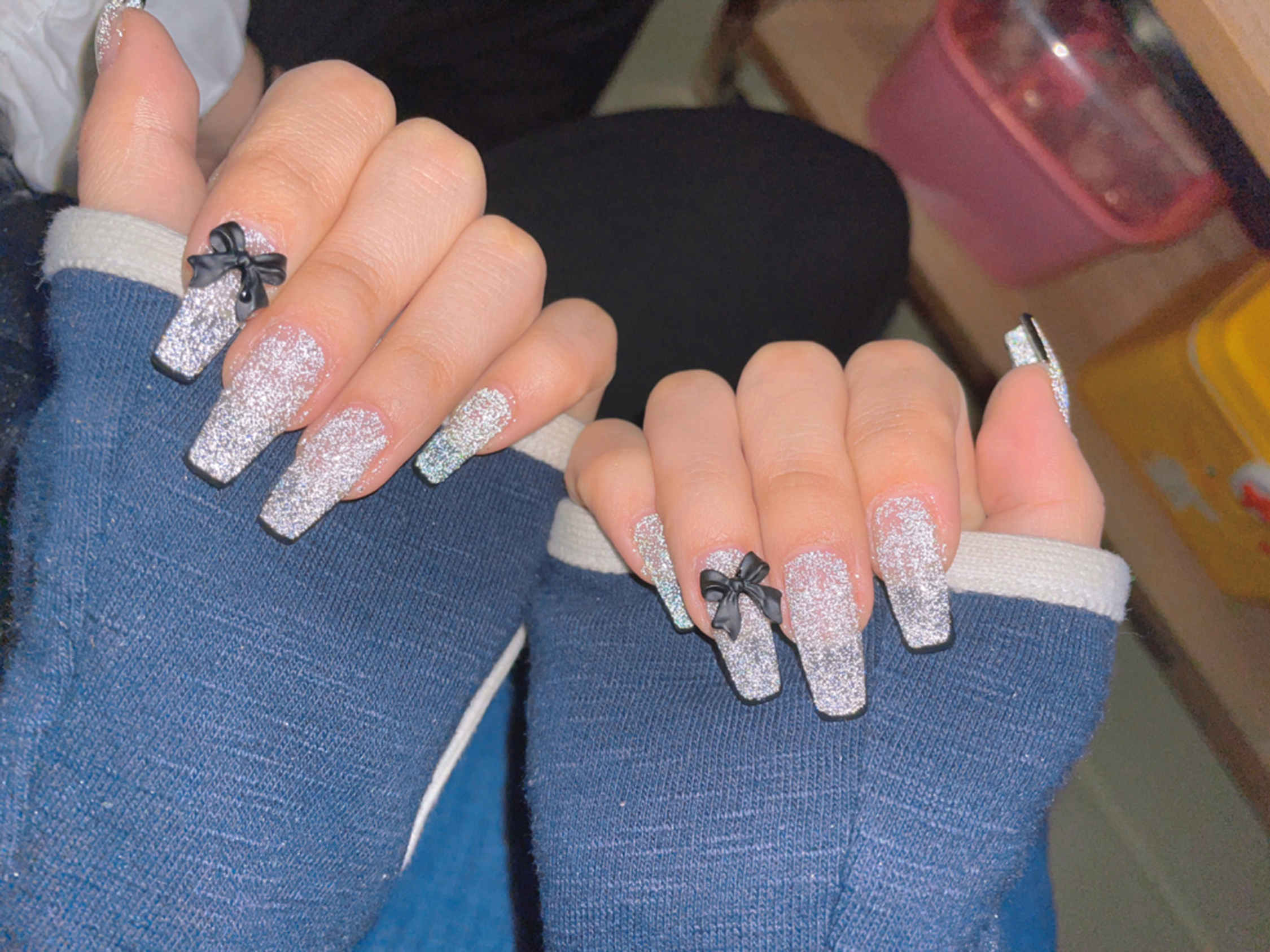 Silver and Black Bow Long Square Nails shown as a nail art design with silver, black, glitter, bow, square and long details.